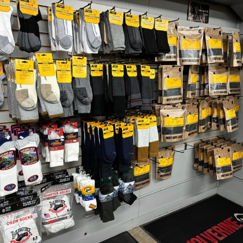 Wall display of various socks in a store, featuring different colors and styles. Bright yellow price tags are visible, creating a vibrant contrast.